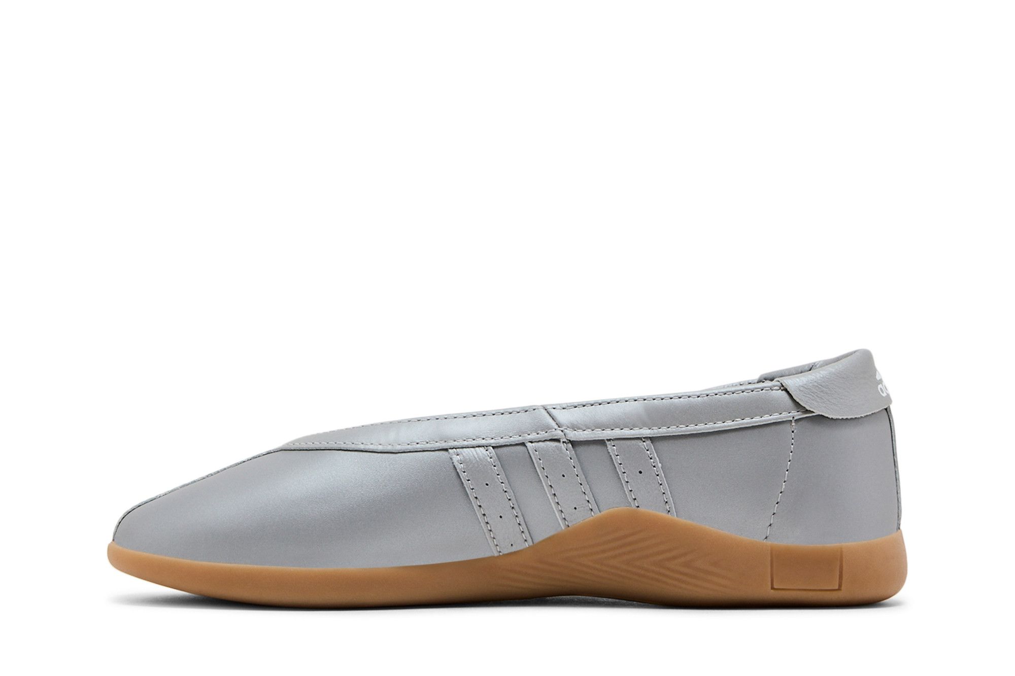 Tênis feminino Wmns Taekwondo Mei Ballet prata metálico em vista lateral, destacando a parte superior lisa, as tiras laterais e a sola marrom. Fundo branco, produto posicionado horizontalmente.