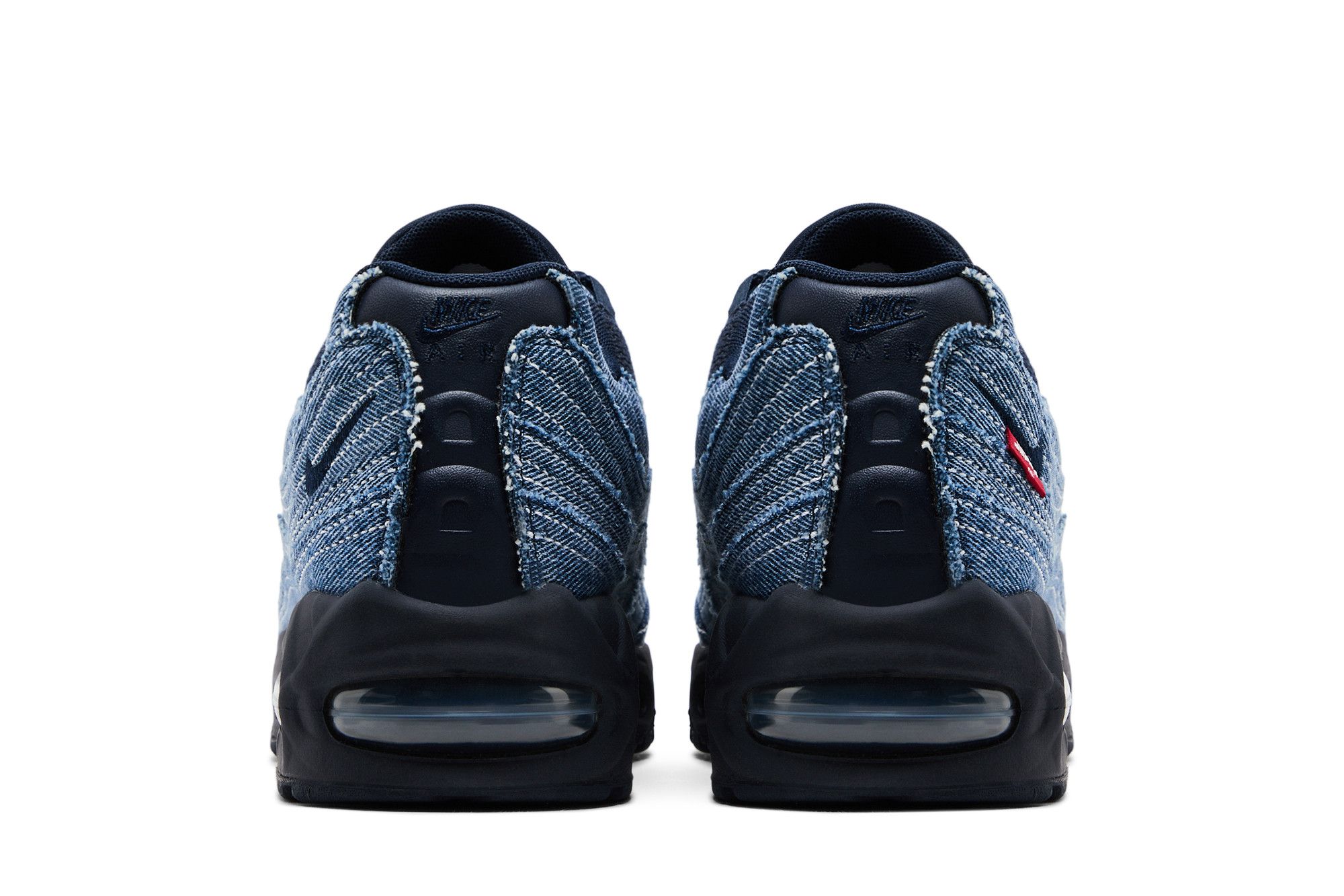 Tênis Levi's x Air Max 95 OG 'Obsidian', vista traseira dos dois pés lado a lado. Cabedal em denim azul, solado preto com amortecimento visível na parte de trás, logo da Nike preta na lingueta.