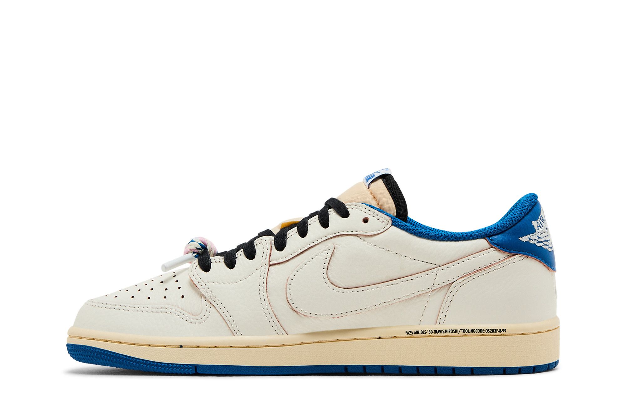 Tênis Air Jordan 1 Retro Low OG SP na lateral esquerda, visual creme com Swoosh da mesma cor, solado azul, cadarços pretos e detalhe escrito próximo à sola. Fundo branco neutro.